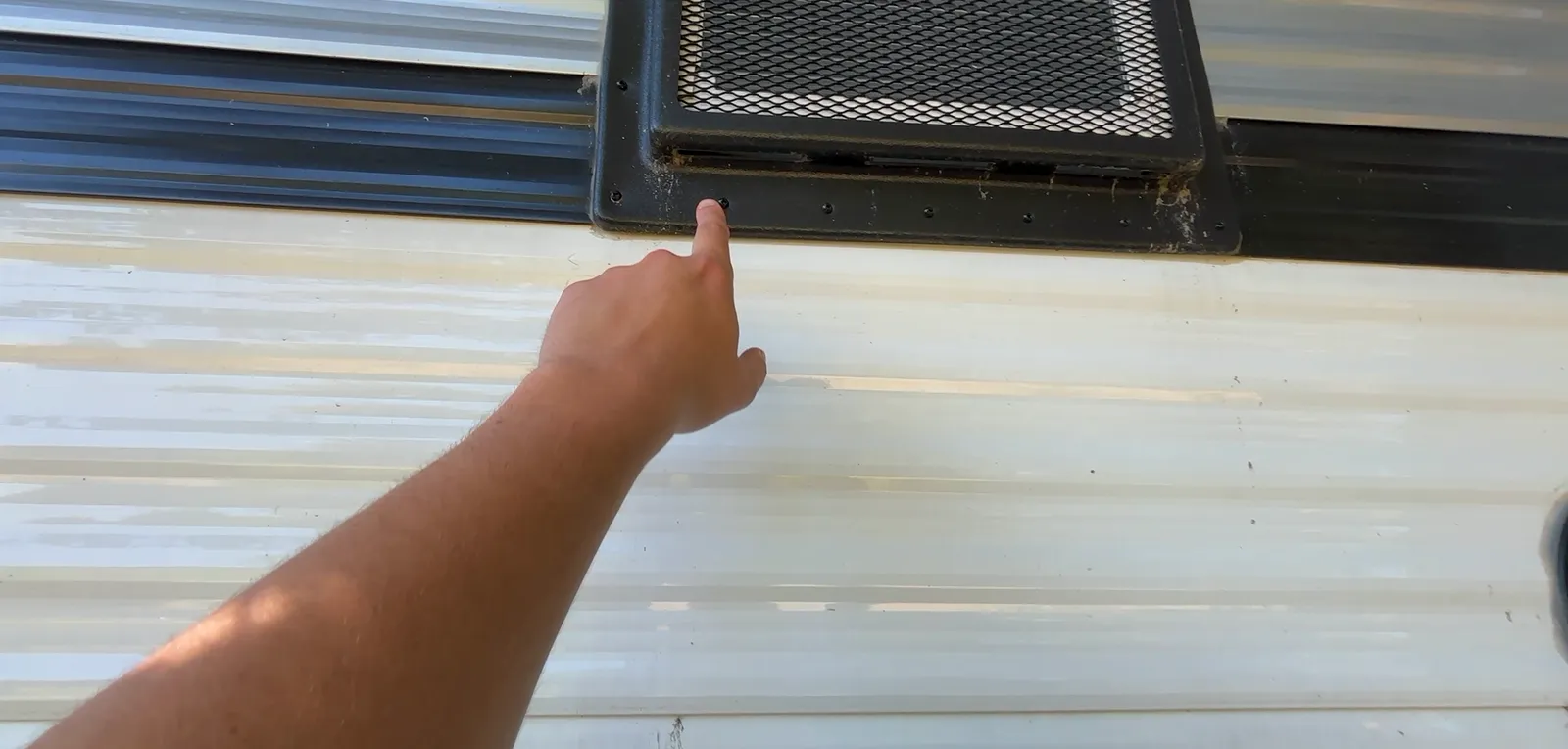 Water and mud streaks down the side of a Coleman 17B from the air conditioner drain