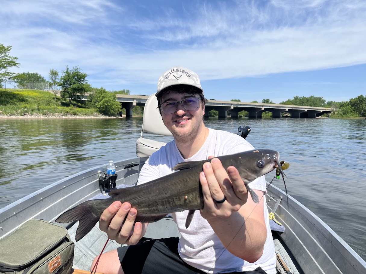 Aaron on the boat with a catfish